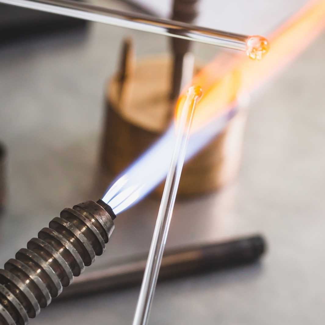 Making glass droplet cluster earrings on a blowtorch.