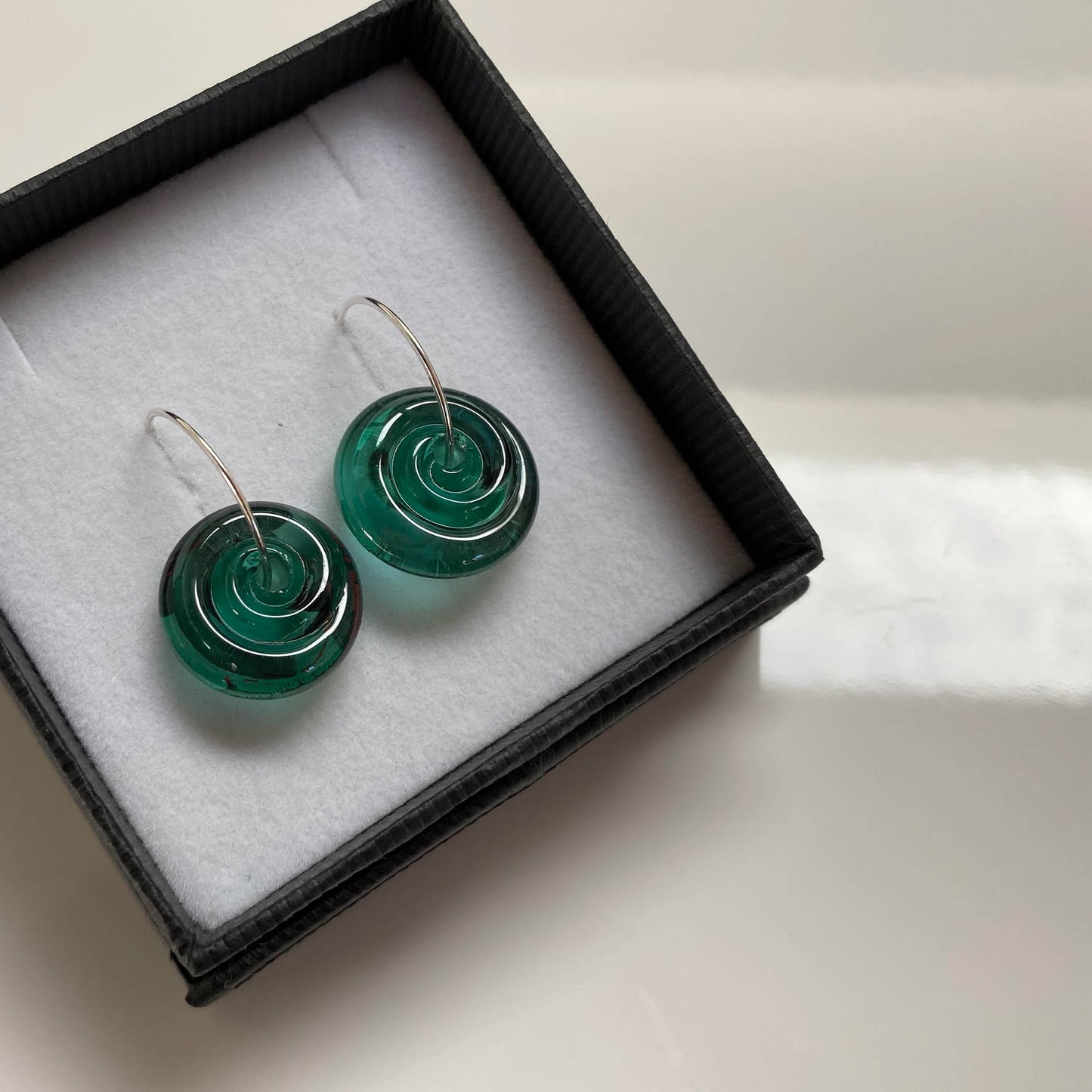 Lampwork glass spiral earrings in sea-green glass.